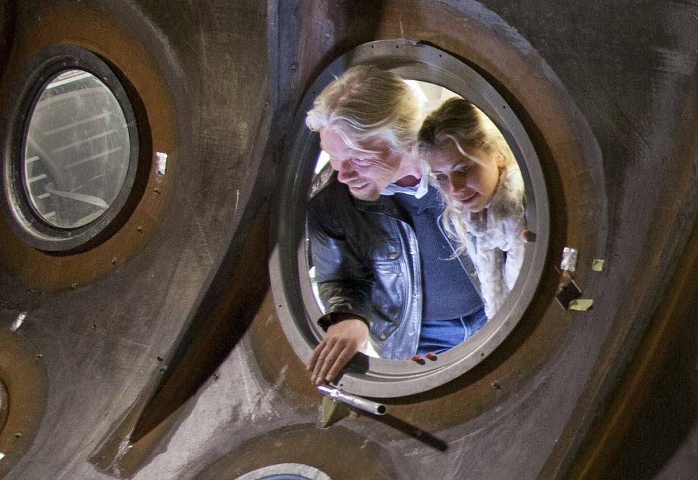 Sir Richard Branson and daughter, Holly, look through the window of a the shell of Virgin Galactic’s SpaceShipTwo. (Image courtesy of Virgin Galactic). Sir Richard Branson and daughter, Holly, look through the window of a the shell of Virgin Galactic’s SpaceShipTwo. (Image courtesy of Virgin Galactic).